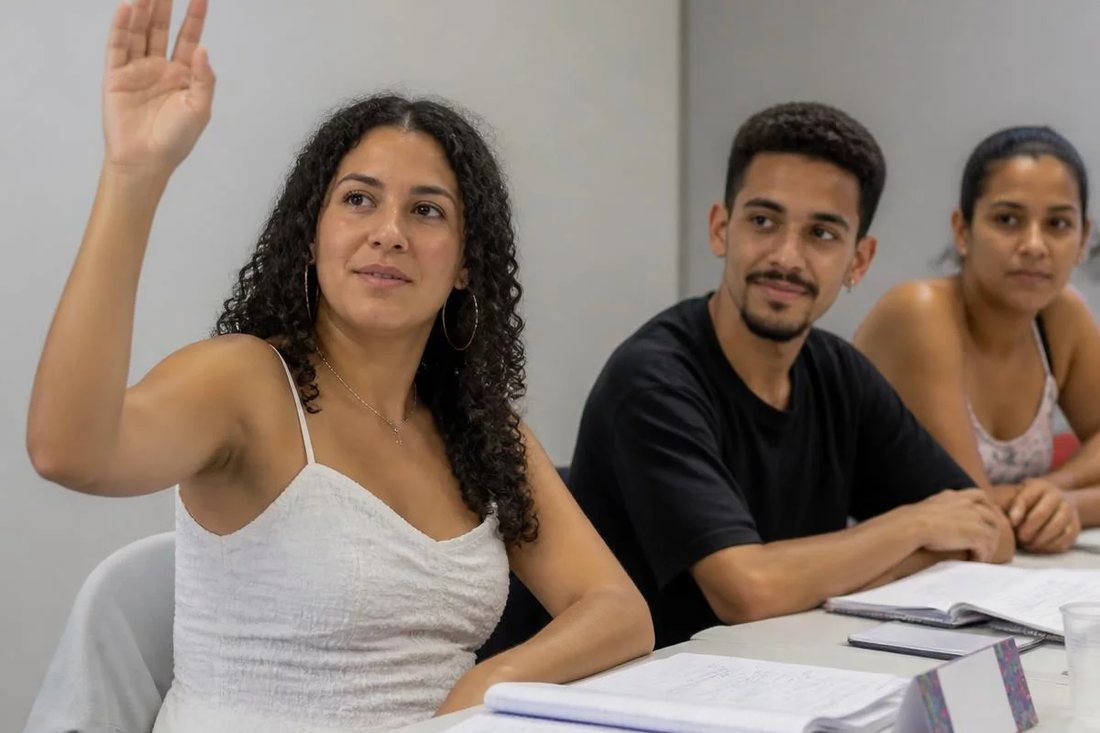 Facilitador em pé apontando para um argumento escrito no quadro durante a sessão